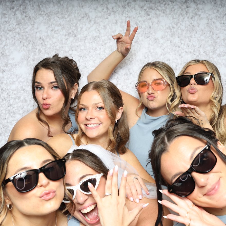 A group of friends in sunglasses blowing kisses at the camera