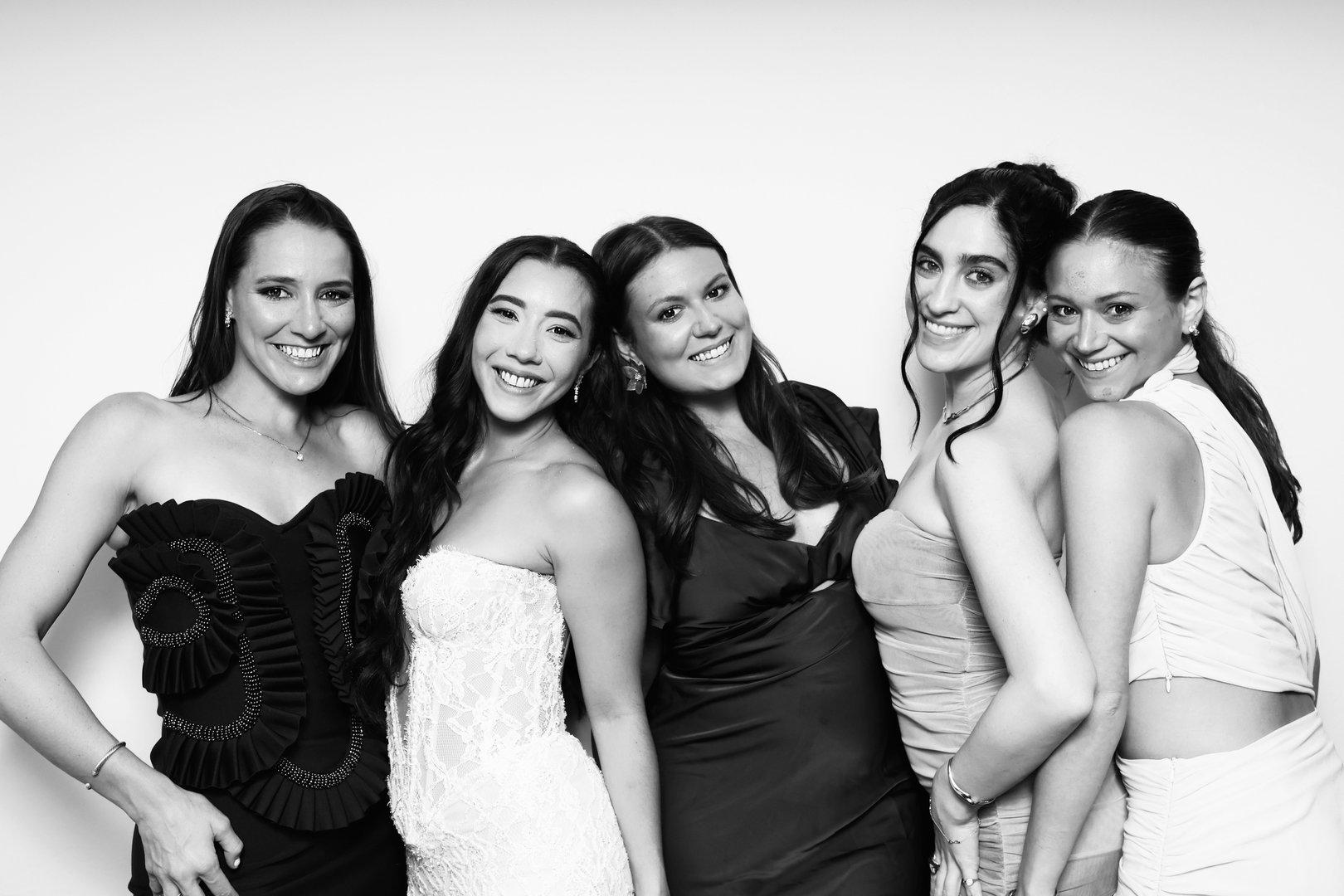 Black and white photo of a group of women in dresses posing together